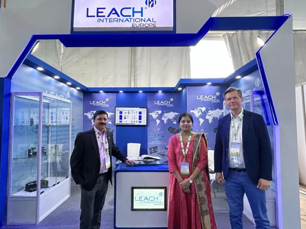 Leach International Europe exhibition stand with three people.